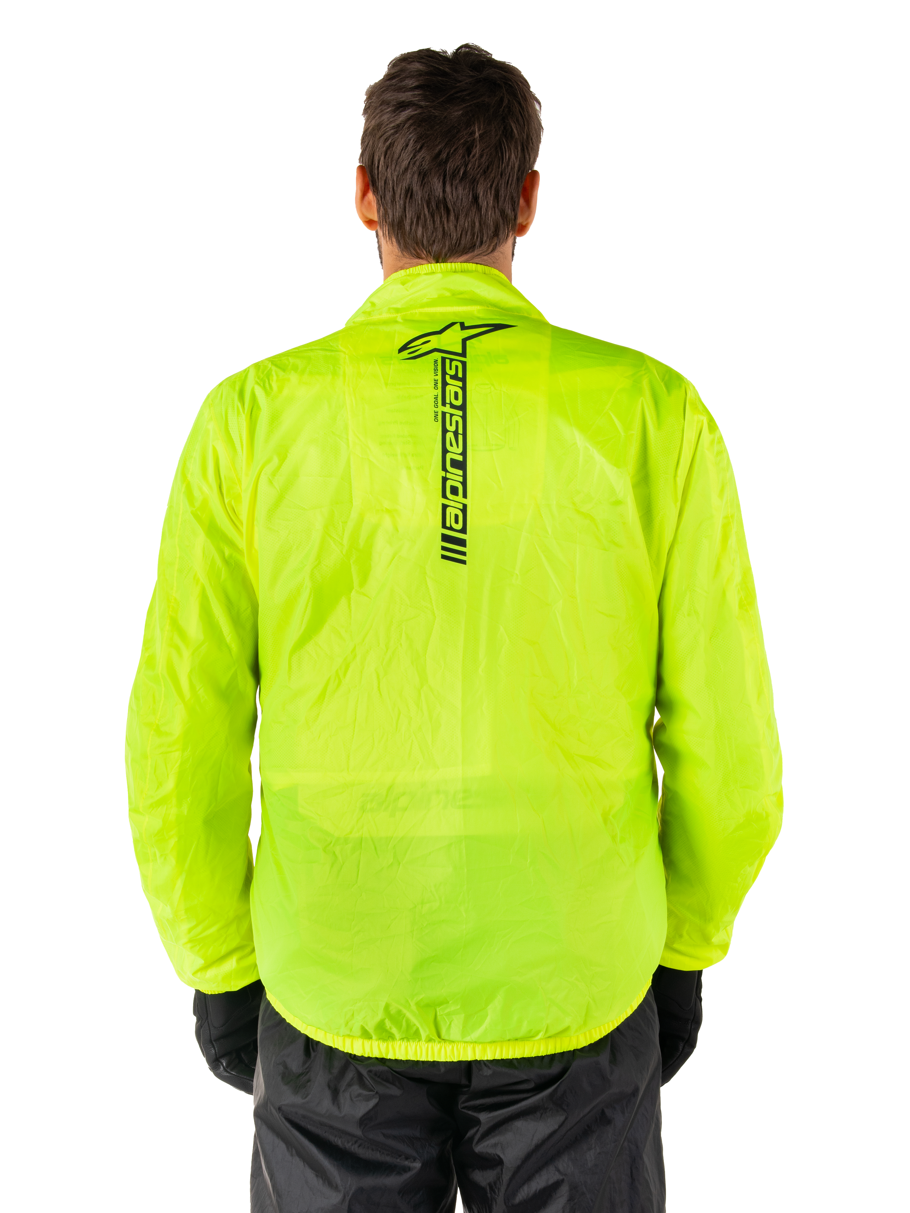 Alpinestars Hurricane Rain V2 Jacket, motocyklowa kurtka przeciwdeszczowa, żółty neonowy, widok z tyłu pokazujący pionowe czarne logo Alpinestars na środku pleców, lekka wodoodporna tkanina, zestawiona z czarnymi spodniami i rękawicami