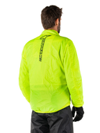 Kurtka przeciwdeszczowa Alpinestars Hurricane Rain V2, żółty fluo, widok z tyłu na modelu, pionowy czarny napis Alpinestars na środku pleców, elastyczny pas i mankiety, wodoodporna i kompaktowa konstrukcja