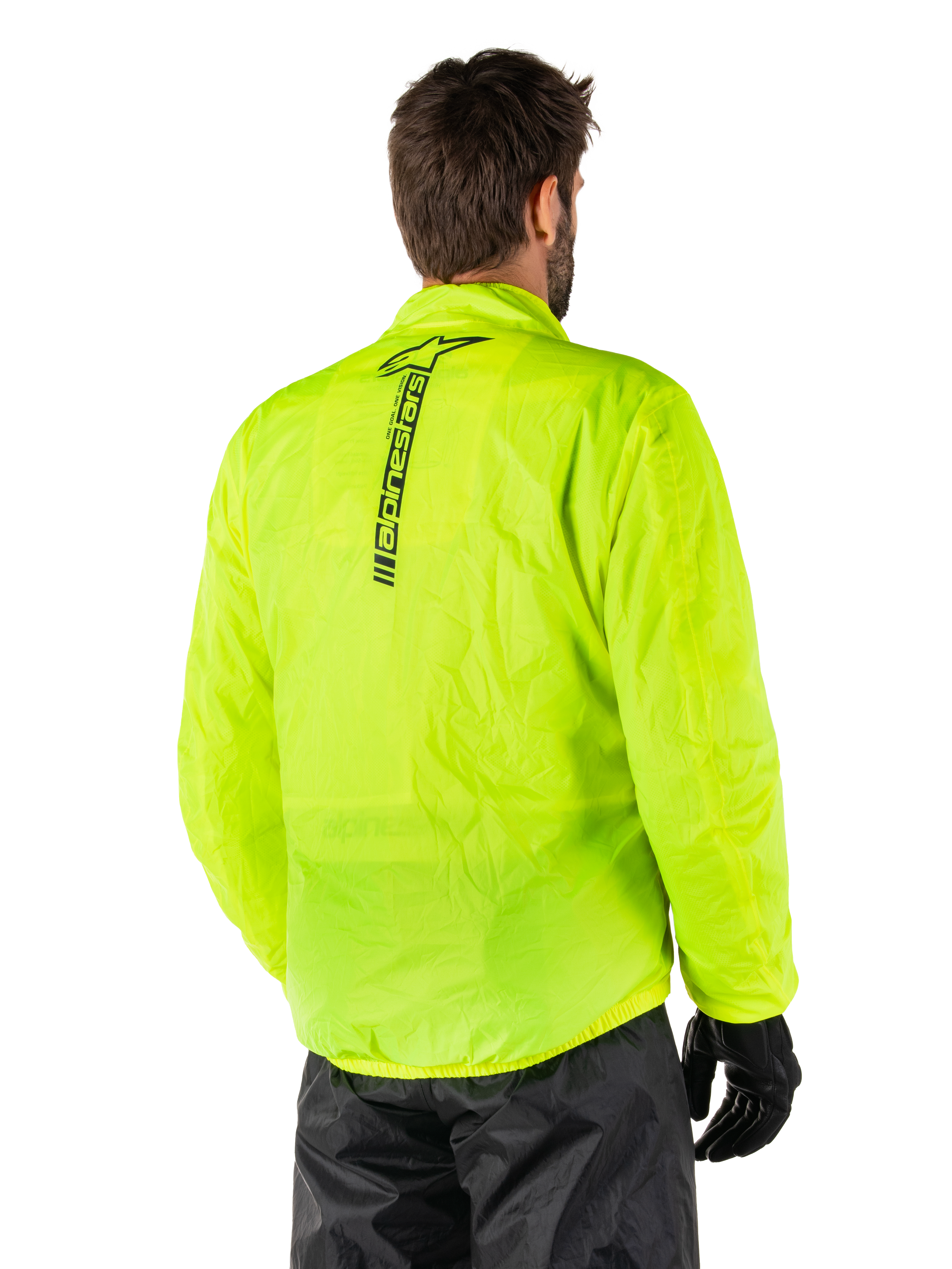 Kurtka przeciwdeszczowa Alpinestars Hurricane Rain V2, żółty fluo, widok z tyłu na modelu, pionowy czarny napis Alpinestars na środku pleców, elastyczny pas i mankiety, wodoodporna i kompaktowa konstrukcja