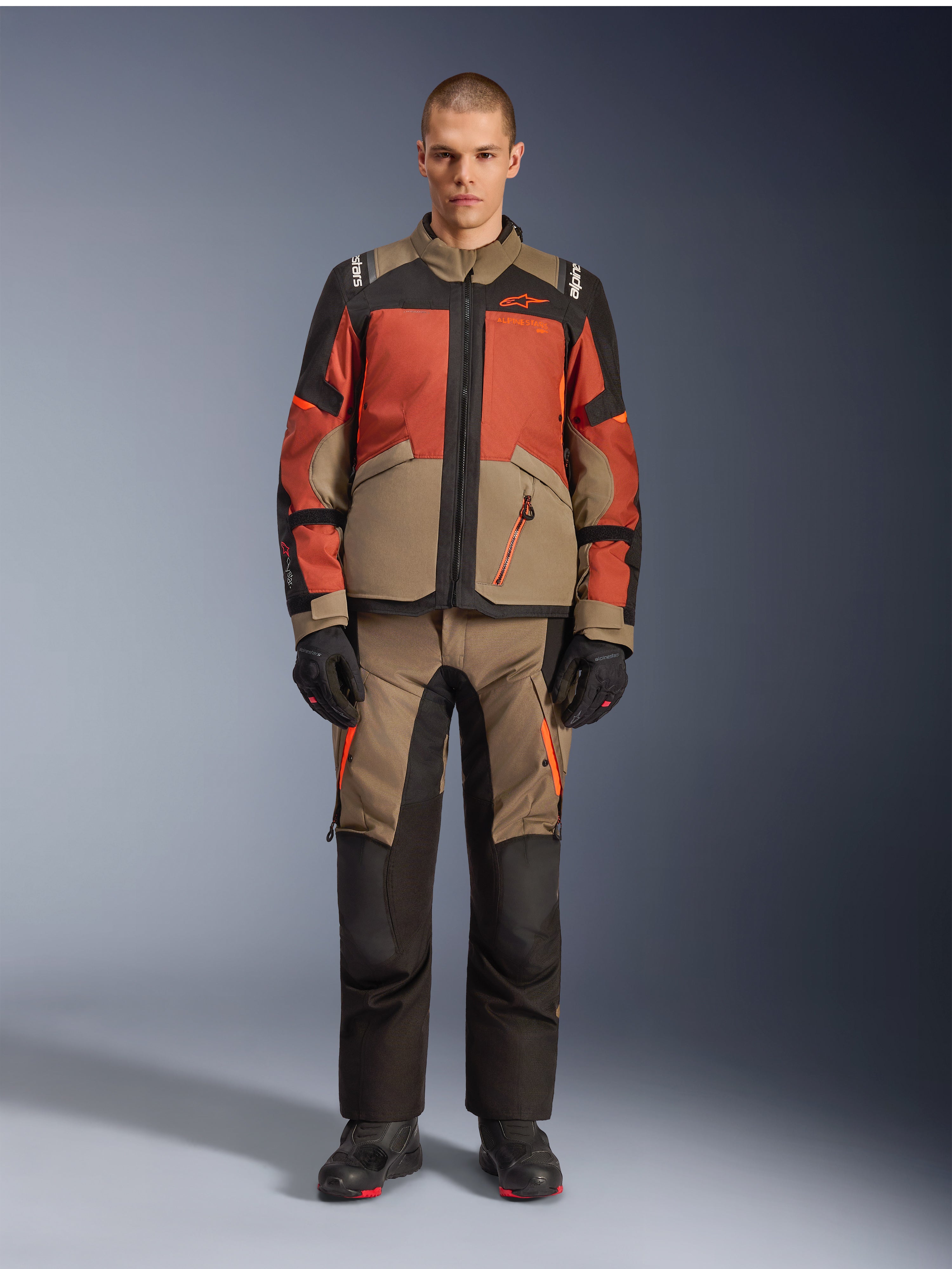 Alpinestars Andes V4 Drystar® Jacket, Adventure Motorcycle Jacket, Walnut Rust Black, worn with matching pants and gloves, multi-tonal design with rust orange and walnut brown panels, durable textile gear for all-terrain riding