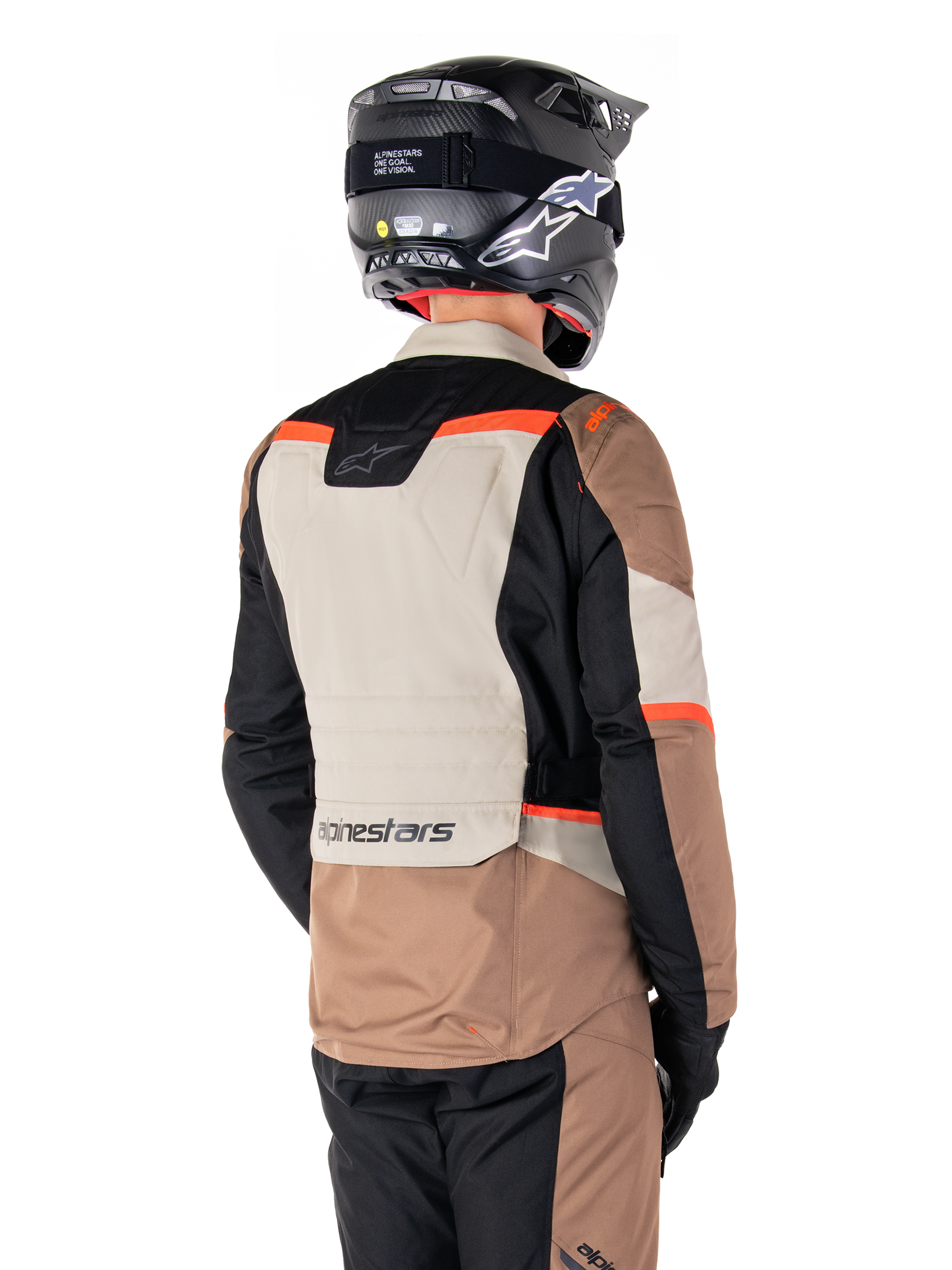 Alpinestars ST-1 Waterproof Jacket, Adventure Touring Jacket, Dark Khaki Sand Black Red Fluo, Back view showing color-blocked textile panels, fluorescent red accents, and Alpinestars branding on the lower back, worn by a rider with a black helmet.