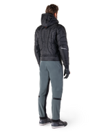 Alpinestars Mohobbs Waterproof Jacket, czarna, widok z tyłu na pikowaną kurtkę bomber z wytłoczonym pionowym napisem na plecach, zestawiona z szarymi spodniami motocyklowymi i czarnymi rękawicami, miejska odzież motocyklowa inspirowana stylem streetwear
