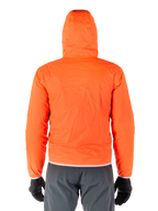 Alpinestars Mohobbs Waterproof Jacket, jaskrawopomarańczowa neonowa pakowalna osłona przeciwdeszczowa, widok z tyłu lekkiej kurtki z kapturem, noszona z ciemnoszarymi spodniami motocyklowymi i czarnymi rękawicami