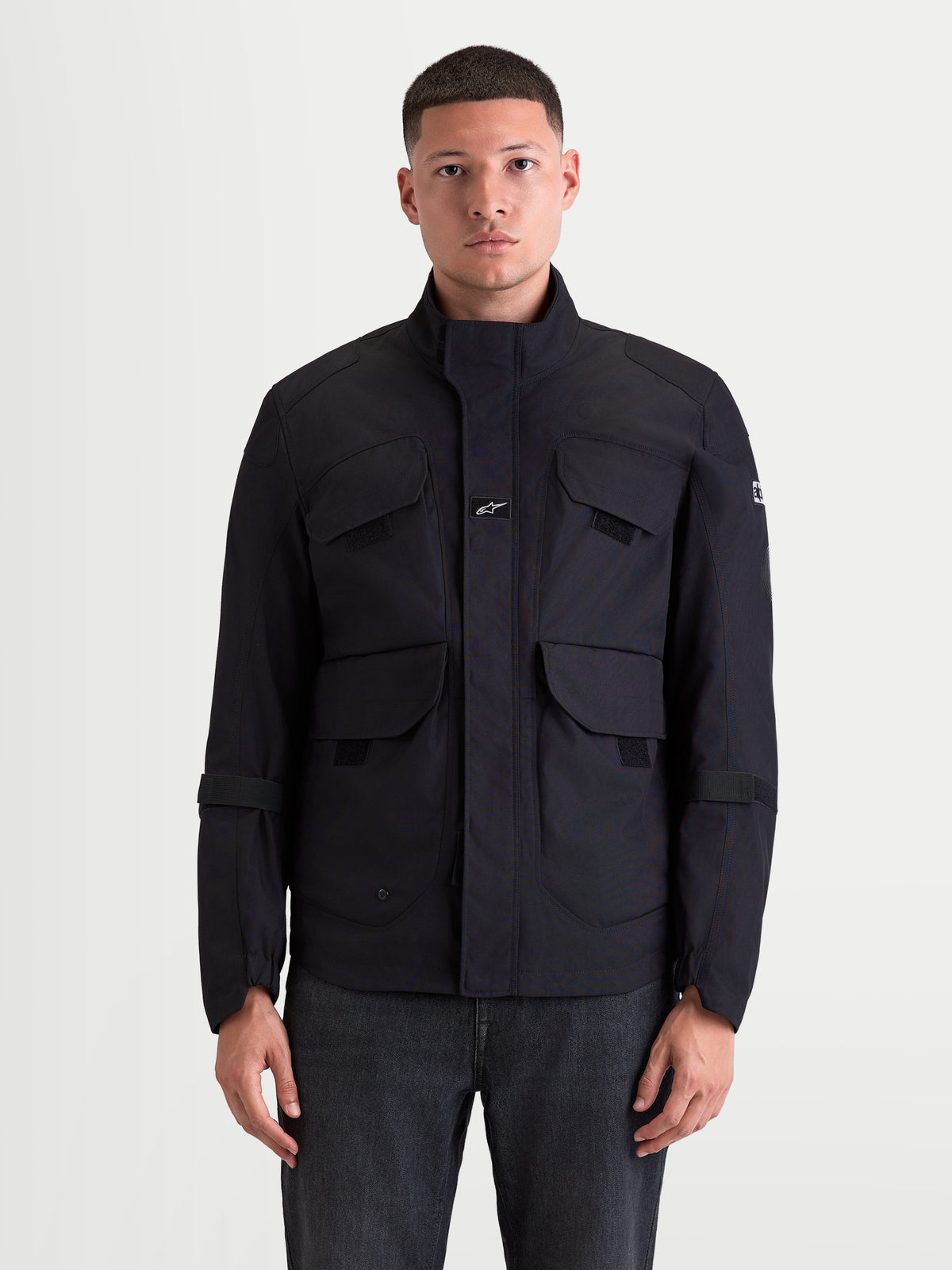Alpinestars Altan Drystar Kurtka motocyklowa męska urban, czarna, widok z przodu na modelu prezentujący matową konstrukcję z poliestru, kieszenie typu cargo i ergonomiczny ciepły kołnierz