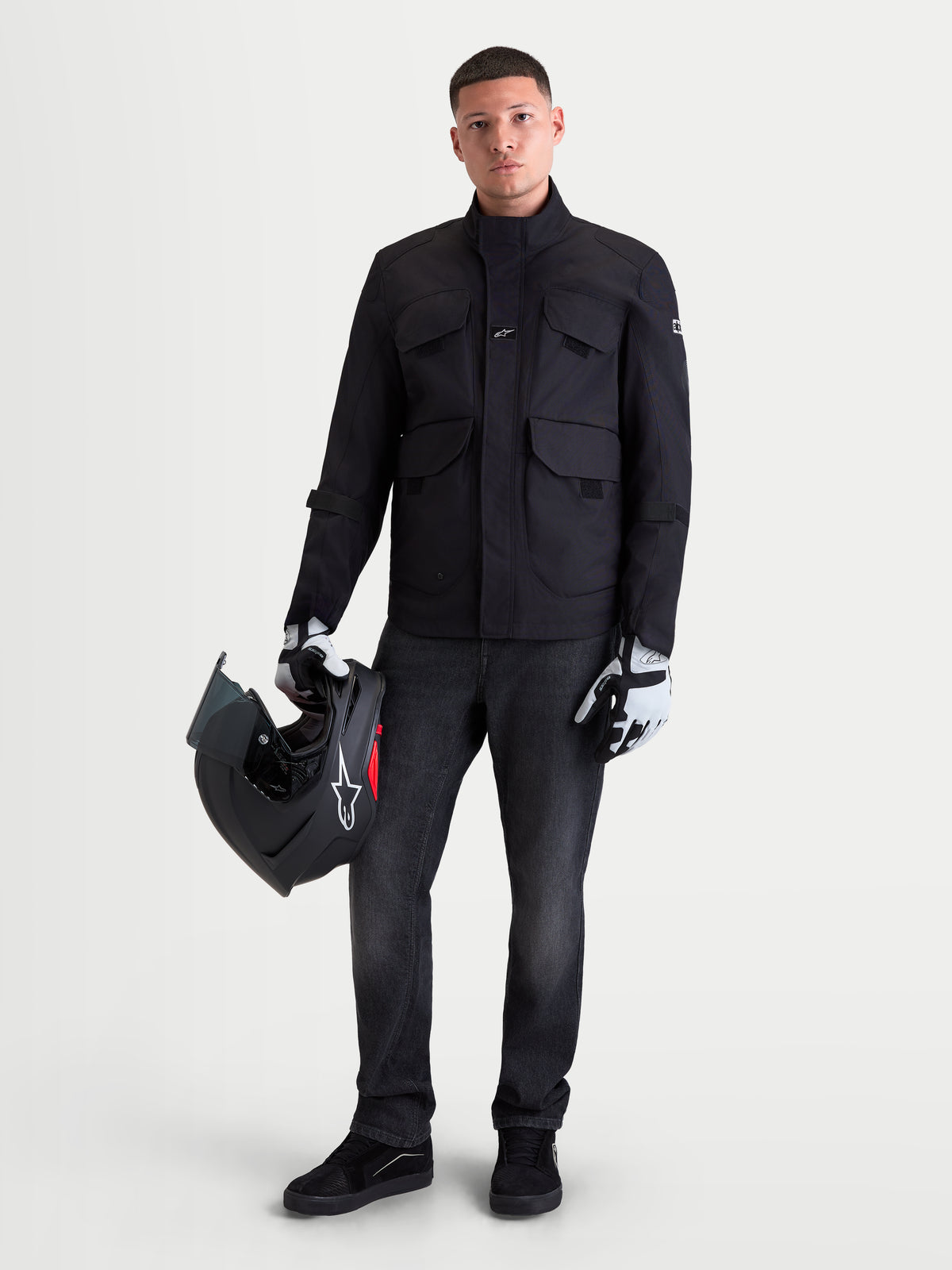 Alpinestars Altan Drystar Kurtka motocyklowa męska urban contemporary, czarna, widok z przodu na model trzymający kask i w rękawicach motocyklowych, wodoodporna kurtka tekstylna z kieszeniami cargo