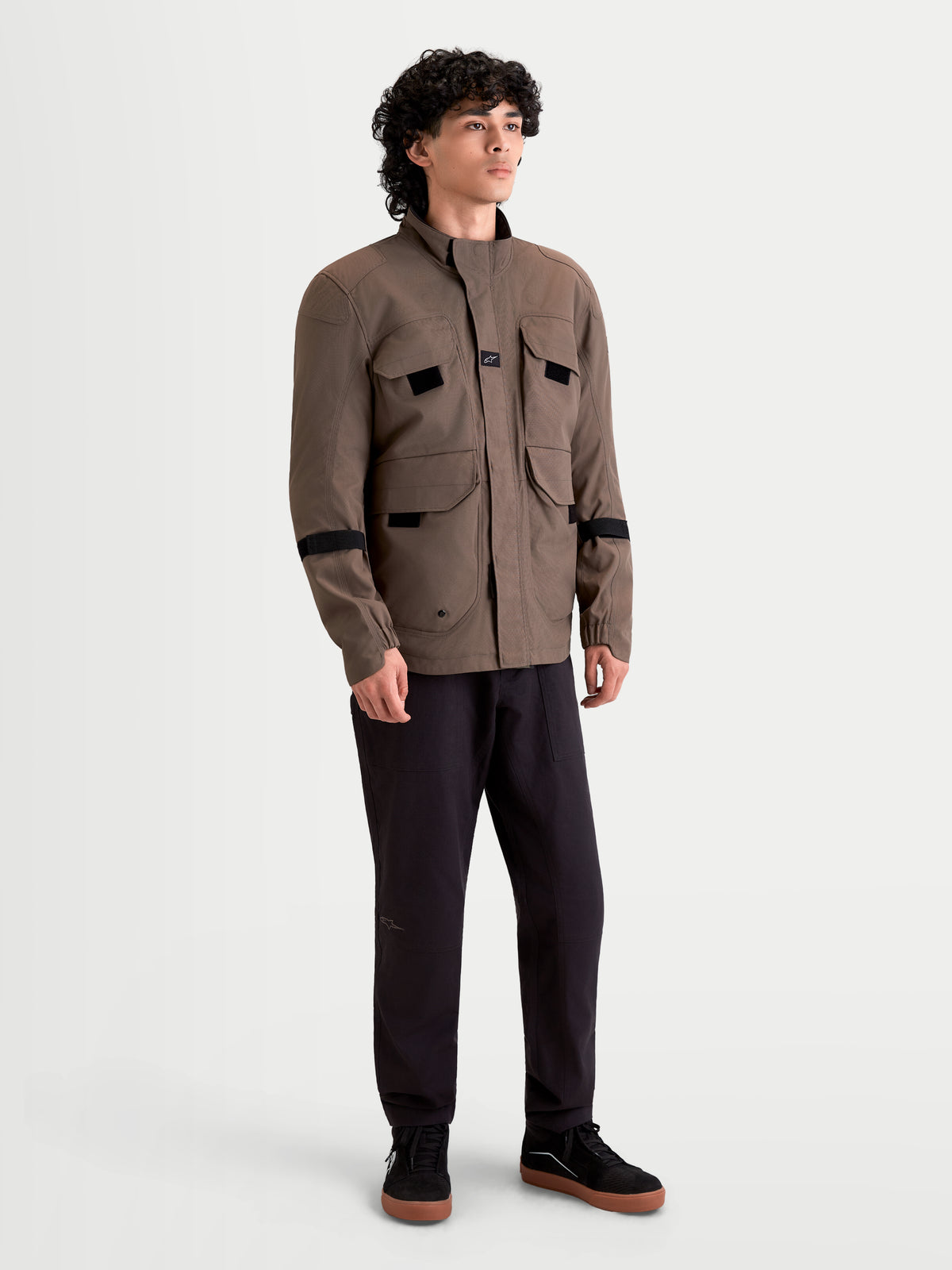 Alpinestars Altan Drystar kurtka motocyklowa męska w kolorze brązowym i czarnym, widok z przodu na modelu prezentującym wodoodporny styl kurtki typu field jacket z kieszeniami cargo