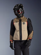 Kurtka Alpinestars Andes Pro Drystar® XF, motocyklowa kurtka adventure touring, beżowo-brązowa (Walnut Aluminum) z czarnymi panelami i czerwonymi akcentami, noszona z czarnym kaskiem i goglami Alpinestars, techniczna odzież motocyklowa