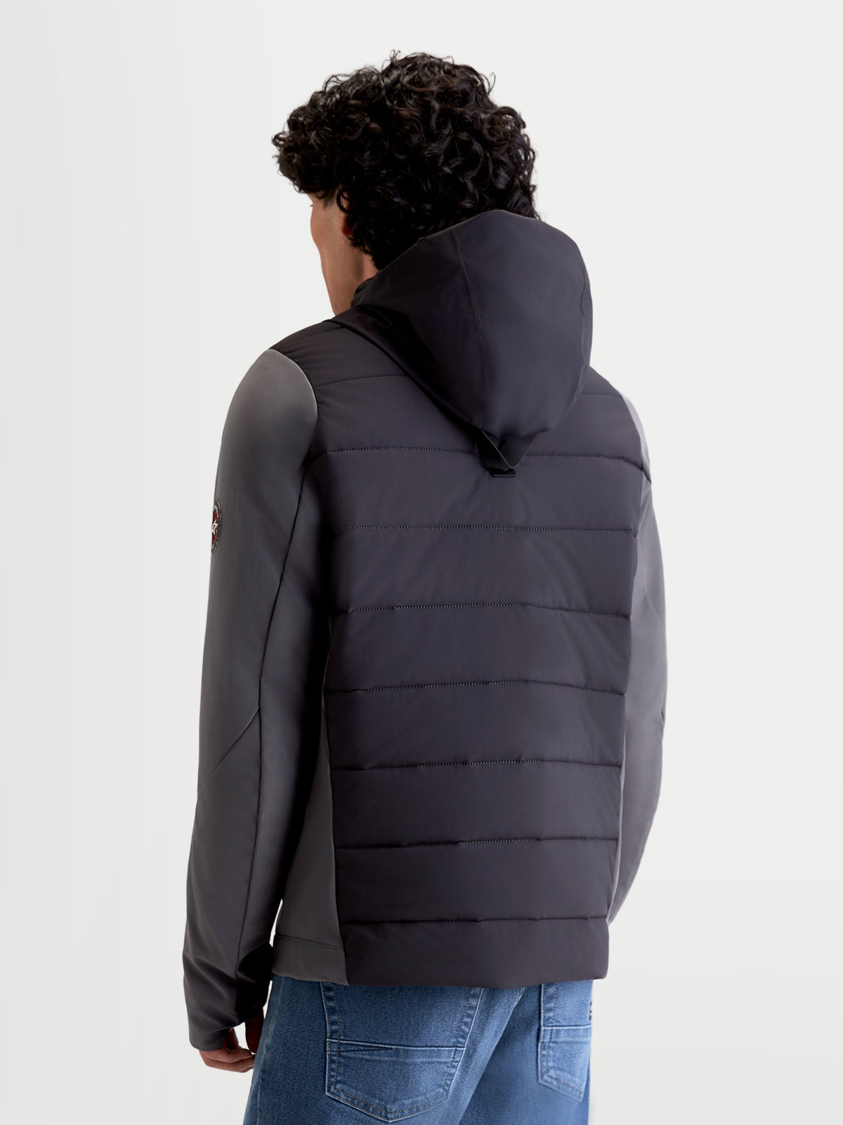 Alpinestars Therma-Tech Waterproof Jacket, miejska męska kurtka motocyklowa tekstylna w kolorze czarnym i ciemnoszarym, widok z tyłu na model prezentujący zintegrowany system kaptura i konstrukcję pikowaną metodą zgrzewania sonicznego
