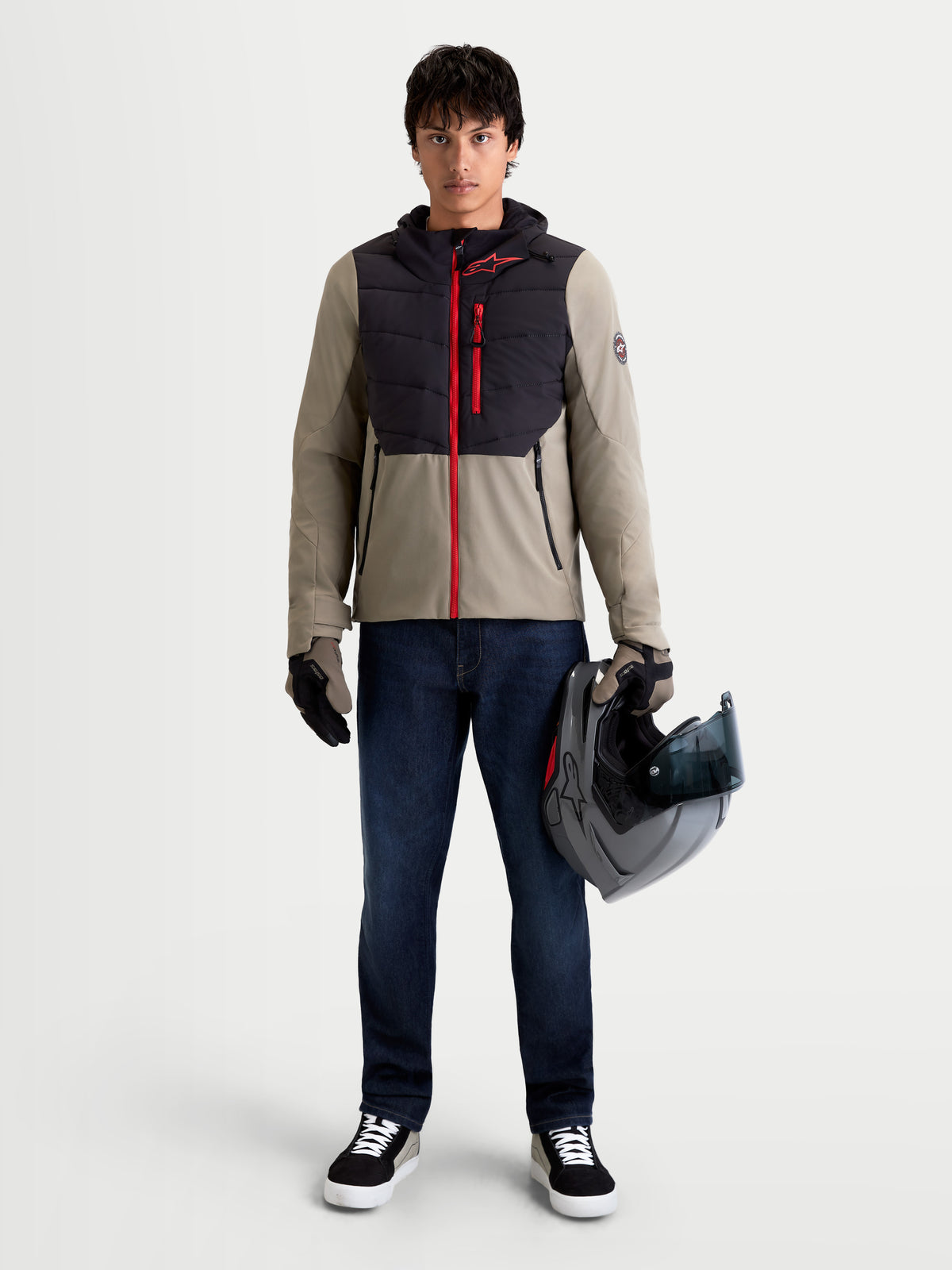 Alpinestars Therma Tech Wp kurtka motocyklowa męska urban contemporary, czarna i beżowa, widok z przodu na model w pasujących rękawicach trzymający kask, wodoodporna i ocieplana odzież szosowa