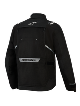 Kurtka Alpinestars Cusco Drystar®, czarna, widok z tyłu, z białym logo gwiazdy w górnej części pleców, odblaskowym napisem Alpinestars w dolnej części pleców, dużym panelem wentylacyjnym na zamek i wytrzymałą konstrukcją tekstylną przeznaczoną do turystyki adventure
