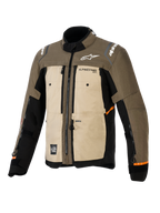 Kurtka Alpinestars Cusco Drystar®, Walnut Aluminum Black, motocyklowa kurtka turystyczna adventure, widok z przodu pod kątem trzech czwartych, tekstylna konstrukcja z beżowymi i brązowymi panelami, otwory wentylacyjne na zamki, białe logo Alpinestars oraz pomarańczowe akcenty na rękawach