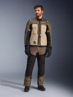 Kurtka Alpinestars Cusco Drystar® w kolorze Walnut Aluminum Black, noszona przez motocyklistę z pasującymi spodniami adventure touring, czarnymi rękawicami i butami, wyposażona w beżowe panele na klatce piersiowej, czarne rękawy z subtelnymi pomarańczowymi akcentami i funkcjonalne zamki wentylacyjne do drogowej jazdy motocyklowej.