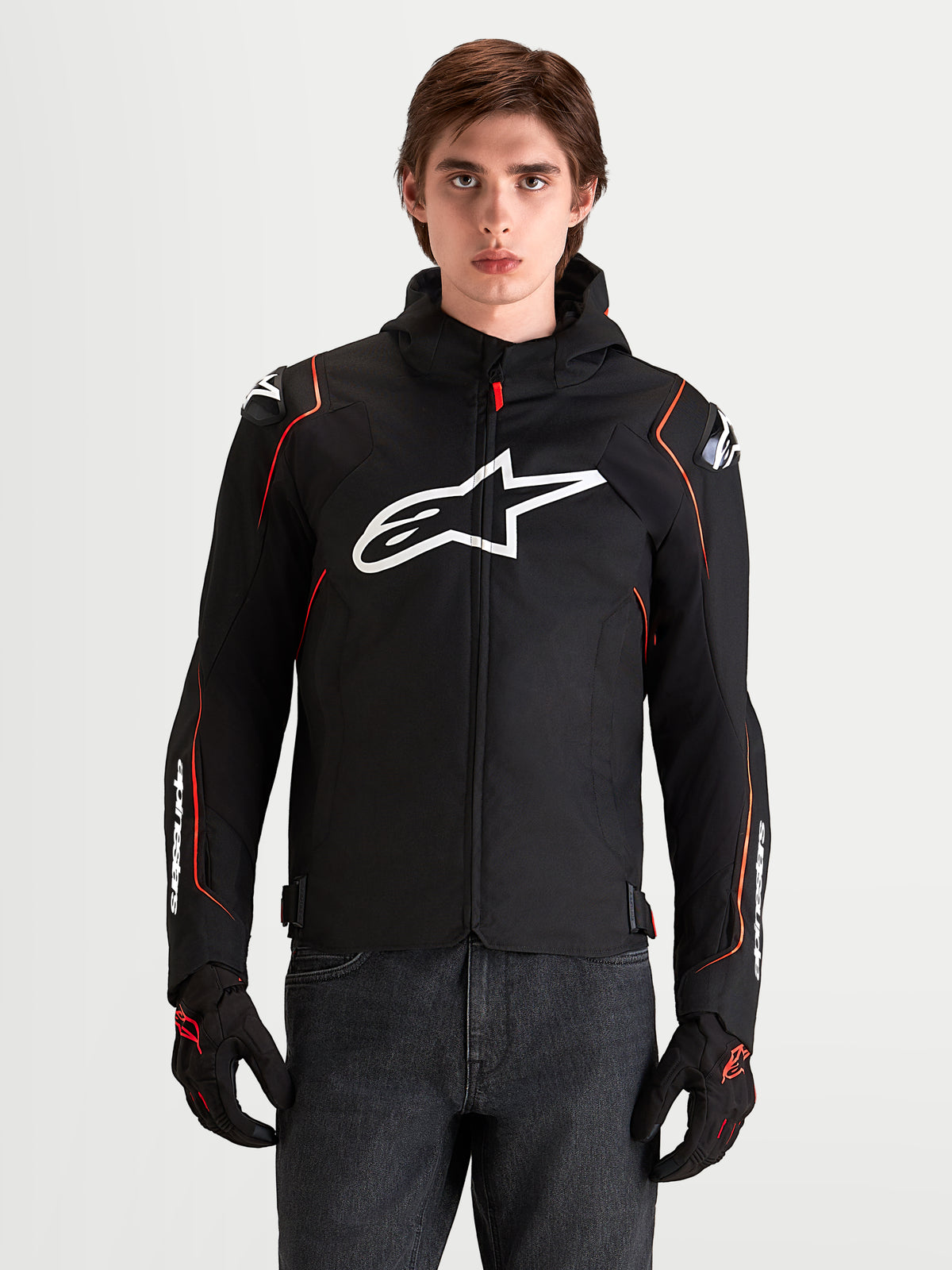 Alpinestars Zaca V2 Waterproof, męska kurtka motocyklowa sportowa, czarna z czerwonymi akcentami i białym logo Astar, prezentowana przez modela w studiu