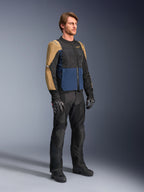 Motocyklista w kurtce Alpinestars ST-2 Air w kolorach Deep Blue, Dark Khaki i czarnym, z dużymi panelami z siatki i perforacjami laserowymi, w zestawieniu z czarnymi spodniami, rękawicami i butami motocyklowymi, tworzący kompletny letni zestaw turystyczny.