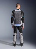 Alpinestars ST-2 Air Jacket, kolor Ice Gray Dark Gray Black, widok z tyłu na modelu, duże siatkowe panele wentylacyjne, niebieskie akcenty i logo Alpinestars, w zestawie z pasującymi spodniami motocyklowymi do adventure touring.