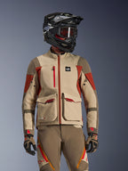 Motocyklista adventure ubrany w kurtkę Maxdura Drystar®XF Laminated Armored Shell w kolorze Aluminum Walnut Rust Brown, z techniczną 3-warstwową konstrukcją, dużymi przednimi kieszeniami cargo i czerwonymi akcentami, w zestawie z czarnym kaskiem SM10, przyciemnianymi goglami oraz pasującymi spodniami i rękawicami adventure.