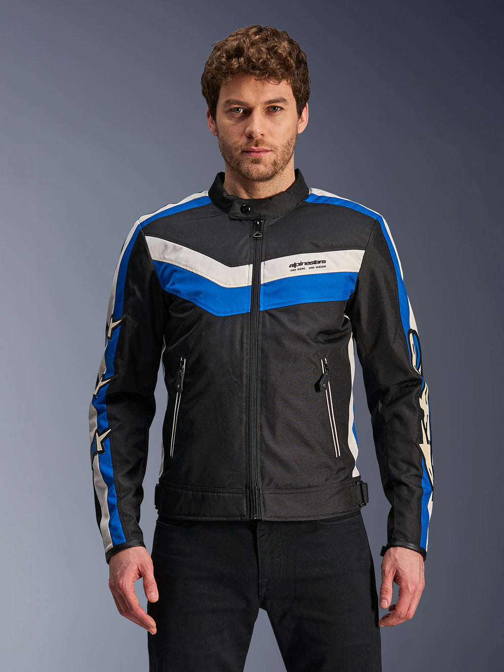 Alpinestars T-Dyno WR Jacket, męska tekstylna kurtka motocyklowa, czarna z niebieskimi i białymi pasami ecru, wzór szewronu na piersi i logo gwiazdy na rękawach, przód i kieszenie zapinane na zamek, styl miejski inspirowany dziedzictwem
