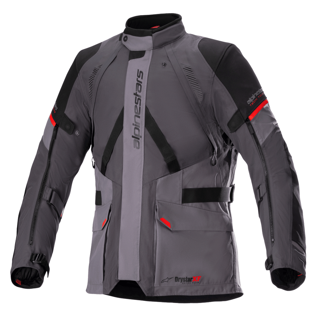 Kurtka Alpinestars Monteira Drystar XF, motocyklowa kurtka turystyczna, ciemnoszara i szara z czarnymi panelami i jaskrawoczerwonymi akcentami, przednie kieszenie cargo, regulowane paski w talii i na rękawach, pionowy napis Alpinestars, wysoki kołnierz, przeznaczona do jazdy adventure