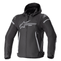 Alpinestars Zaca Waterproof Jacket, motocyklowa kurtka sportowa, czarno-ciemnoszara, z odpinanym kapturem, dużym szarym logo na klatce piersiowej, jasnoszarymi akcentami na ramionach i bokach, regulowanymi paskami w talii i zamkiem błyskawicznym z przodu, sportowa konstrukcja tekstylna