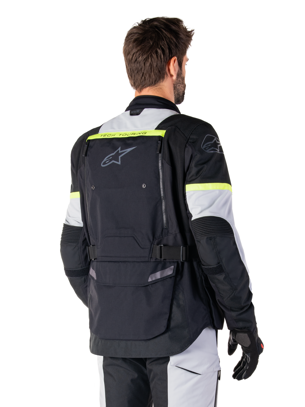 Kurtka Alpinestars Bogotá Pro Drystar®, kurtka adventure touring, kolor czarny, szary Ice Gray i żółty fluo, widok z tyłu z dużą kieszenią na plecach, napisem „TECH TOURING”, logo Alpinestars i neonowymi akcentami, techniczna tekstylna odzież motocyklowa