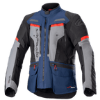 Alpinestars Bogota Pro Drystar Jacket, motocyklowa kurtka turystyczna adventure, ciemnoniebieska i czarna z szarymi panelami na klatce piersiowej i jaskrawoczerwonymi akcentami, wodoodporna konstrukcja tekstylna, liczne zamki wentylacyjne i kieszenie użytkowe.