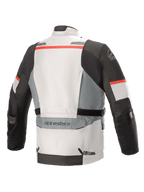 Kurtka Alpinestars Andes V3 Drystar®, kolor lodowoszary i ciemnoszary z czerwonymi akcentami, widok z tyłu z dużą kieszenią użytkową na dole pleców, regulowanymi paskami w talii i odblaskowymi detalami na ramionach oraz dolnej krawędzi.