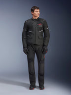 Alpinestars Andes Air Drystar® Pants, motocyklowe spodnie turystyczne, czarne, z siatkowymi panelami wentylacyjnymi i czerwonym logo na nogawce, noszone jako część pełnego stroju z pasującą kurtką i rękawicami, profesjonalna odzież turystyczna adventure