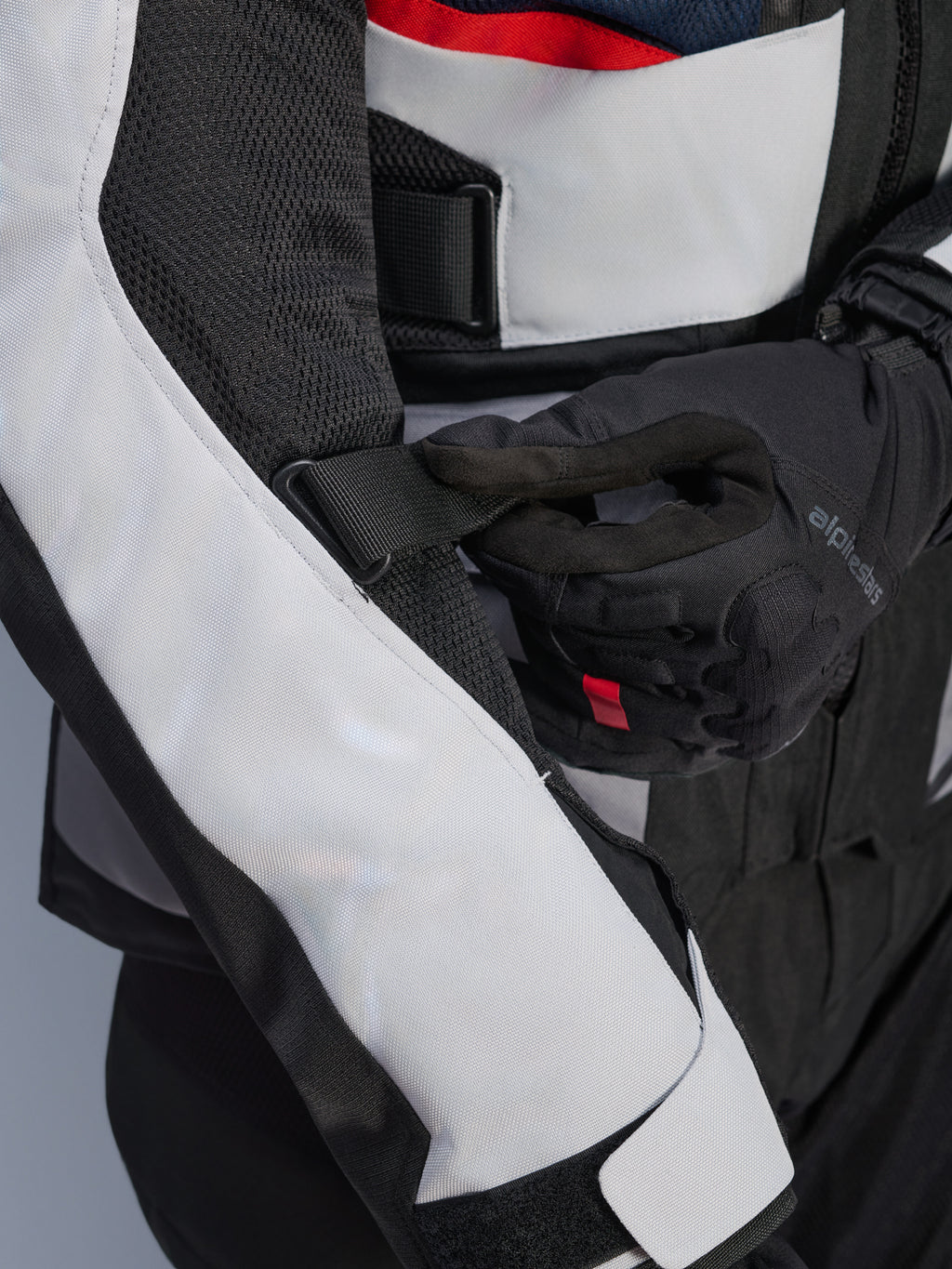 Alpinestars Andes Air Drystar® Jacket w kolorze Deep Blue Black Ice Gray, zbliżenie na regulowany pasek na rękawie i siatkowe panele wentylacyjne, wytrzymała konstrukcja tekstylna do turystyki przygodowej