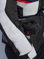 Alpinestars Andes Air Drystar® Jacket w kolorze Deep Blue Black Ice Gray, zbliżenie na regulowany pasek na rękawie i siatkowe panele wentylacyjne, wytrzymała konstrukcja tekstylna do turystyki przygodowej