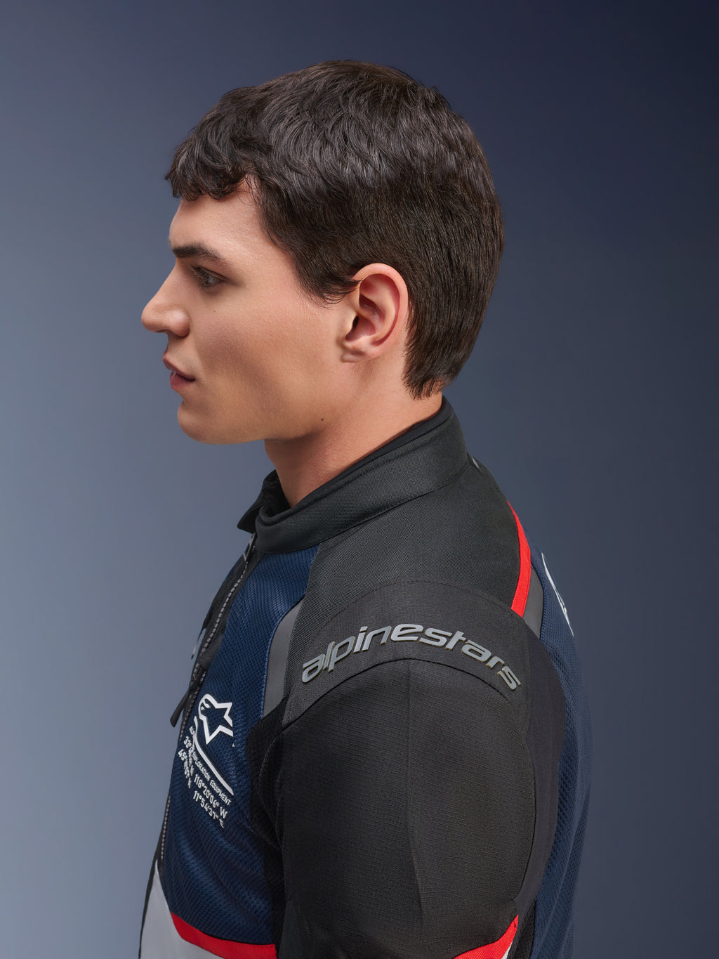 Kurtka Alpinestars Andes Air Drystar®, kolorystyka Deep Blue Black Ice Gray, boczny profil modela w tekstylnej kurtce z siatki, widoczne logo Alpinestars na ramieniu i czerwone akcenty, turystyczna odzież motocyklowa na dwie pory roku