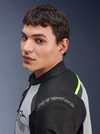 Zbliżenie na modela w kurtce Alpinestars Andes Air Drystar® w kolorach Ice Gray, Dark Gray i czarnym, z neonowożółtymi akcentami i panelami z siatki oraz widocznym logo Alpinestars na ramieniu.