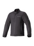 Alpinestars Husker Waterproof Jacket, czarna miejska kurtka motocyklowa, tkanina softshell o wysokiej gęstości, wysoki kołnierz z zatrzaskiem, pełny zamek z przodu, regulacja w pasie i mankietach, subtelne logo na piersi i odblaskowe akcenty na rękawach.