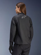 Kurtka Alpinestars Stella Andes Air Drystar®, damska kurtka motocyklowa, czarna, widok z tyłu pokazujący srebrne logo gwiazdy, zestawiona z czarnymi spodniami i rękawicami, lekka wodoodporna odzież turystyczna