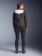 Widok z tyłu modelki ubranej w kurtkę Alpinestars Stella T-Dyno WR w kolorystyce Black Ecru Bright Red, z charakterystycznym kremowym panelem na plecach i czerwonymi akcentami logo, w zestawieniu z czarnymi spodniami i butami, tekstylna kurtka motocyklowa w stylu vintage.