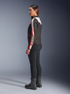 Kurtka Alpinestars Stella T-Dyno WR, damska tekstylna kurtka motocyklowa, czarna, ecru i jaskrawoczerwona, design inspirowany stylem vintage z logo Astars na rękawie, noszona z dopasowanymi czarnymi spodniami i czarnymi butami, krótki motocyklowy krój do jazdy miejskiej