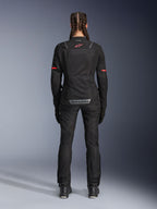 Spodnie Alpinestars Stella Andes Air Drystar®, damskie spodnie motocyklowe, czarne, widok z tyłu, noszone z pasującą kurtką z siateczki z czerwonymi akcentami, eksponujące siatkowe panele wentylacyjne i odblaskowe logo na dole pleców, zaprojektowane do jazdy adventure i turystyki szosowej