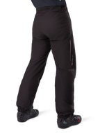 Podpinka Alpinestars Amt-8 Stretch Drystar® XF, czarna, widok z tyłu przedstawiający wodoodporną warstwę założoną na czarne buty motocyklowe, logo Drystar XF na dole nogawki, elastyczne mankiety, lekki i rozciągliwy materiał do turystyki przygodowej.