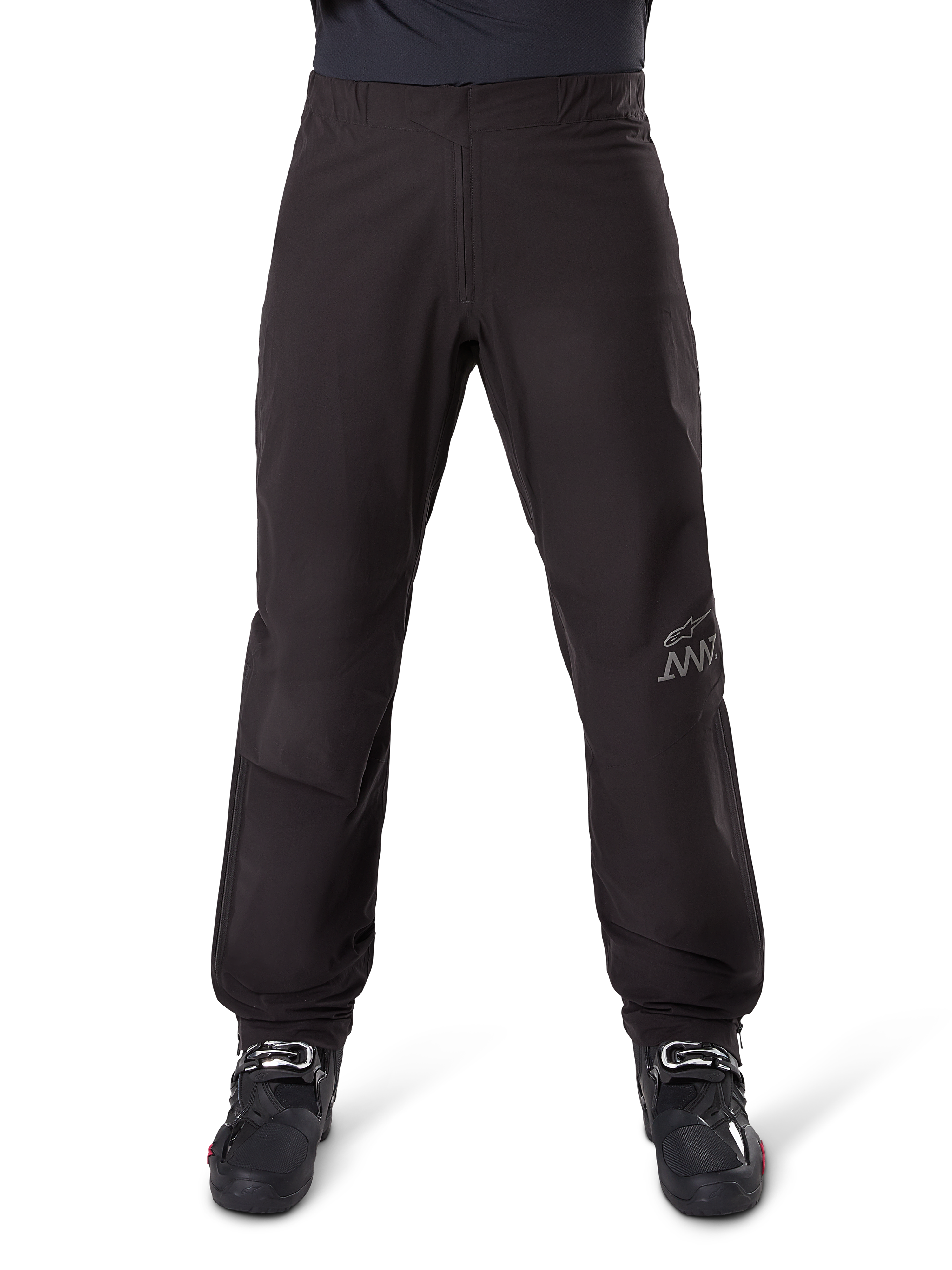 Alpinestars AMT-8 Stretch Drystar® XF Pant Liner, czarna podszewka do spodni motocyklowych, widok z przodu w czarnych butach motocyklowych, szare logo gwiazdy i branding AMT na nogawce, wszechstronna wodoodporna i wiatroodporna odzież motocyklowa