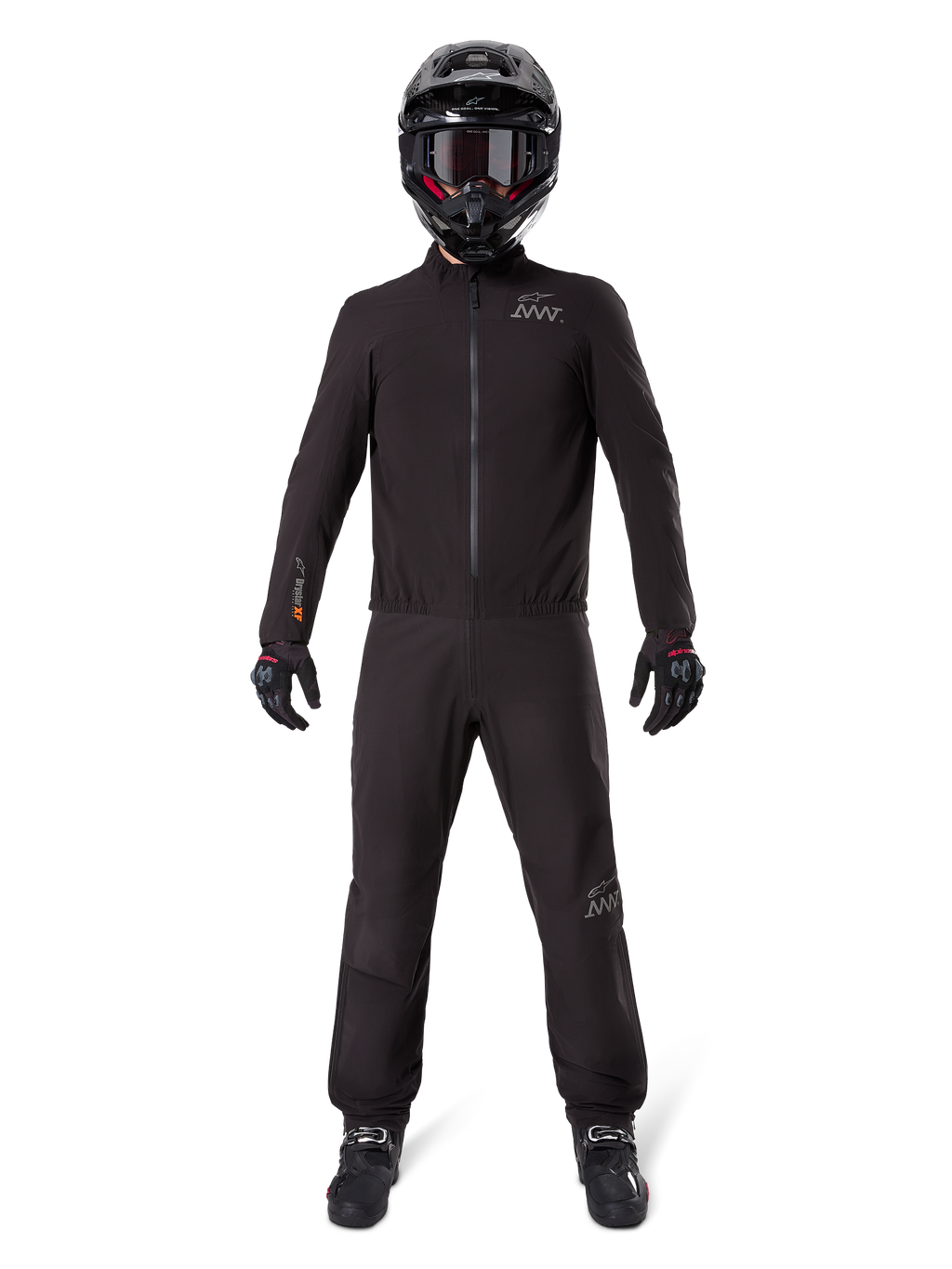 Motocyklista ubrany w podszewkę spodni Alpinestars AMT-8 Stretch Drystar® XF i pasującą kurtkę, czarny wodoodporny i wiatroszczelny strój techniczny, czarny kask, rękawice i buty, elegancki design adventure touring