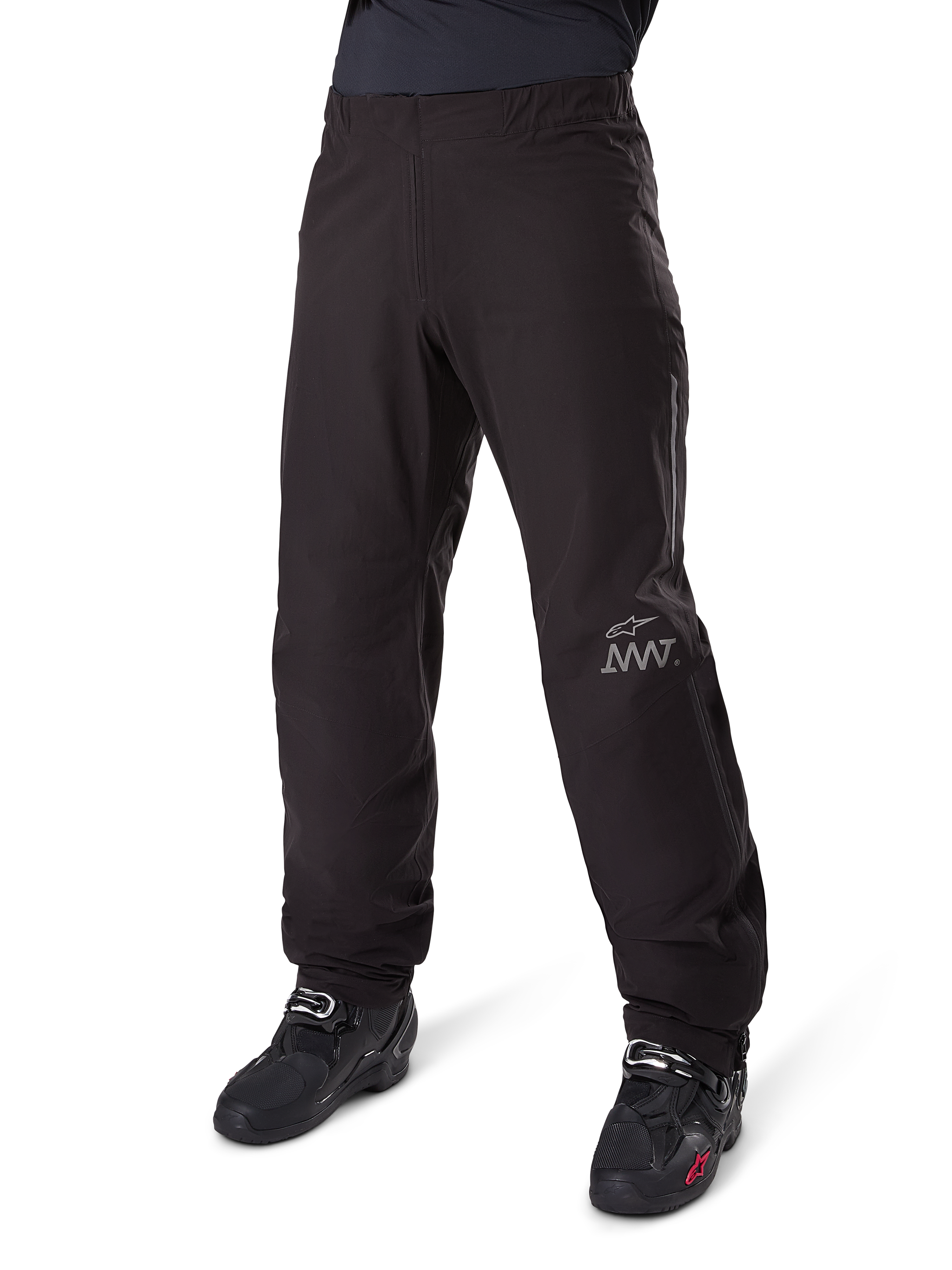 Alpinestars Amt-8 Stretch Drystar® XF Pant Liner, czarna, wodoodporna i elastyczna konstrukcja tekstylna ze srebrnym logo AMT, noszona z czarnymi butami motocyklowymi, element odzieży adventure touring.
