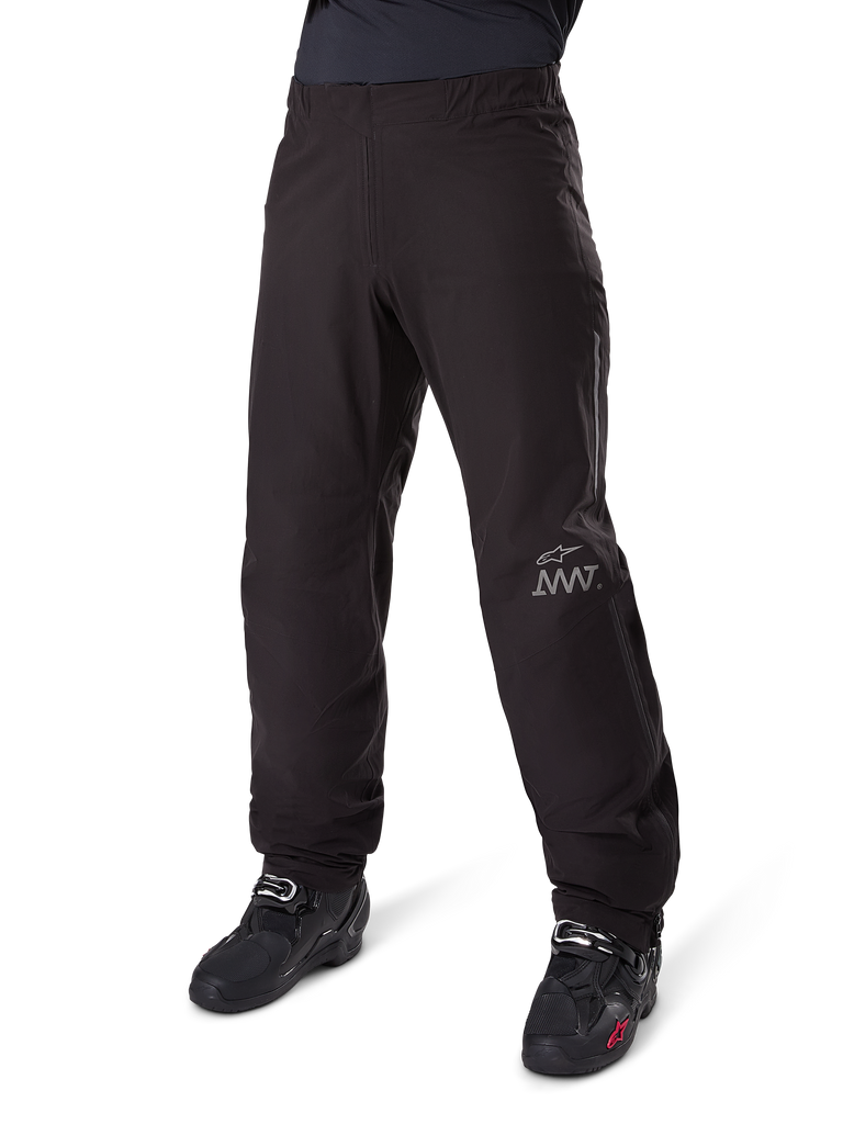 Alpinestars Amt 8 Stretch Drystar® XF Pant Liner, Waterproof Motorcycle Pants, Black, featuring a grey AMT logo on the lower left leg, worn with black motorcycle boots, functional design for all-weather adventure riding