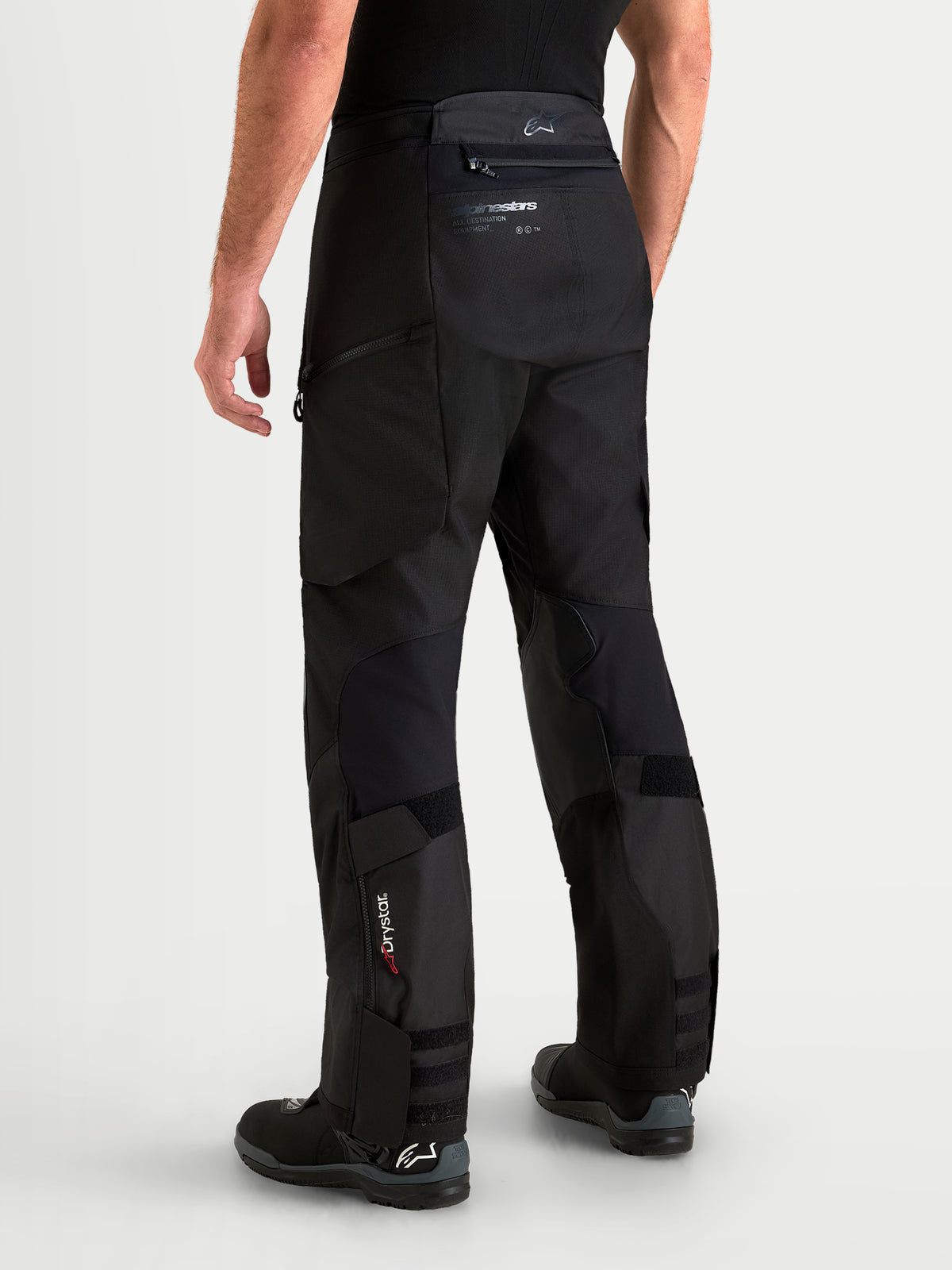 Alpinestars Harok V2 Drystar, męskie czarne spodnie motocyklowe adventure, widok z tyłu na trwałą konstrukcja ripstop, branding Drystar na dole nogawki i design over-the-boot