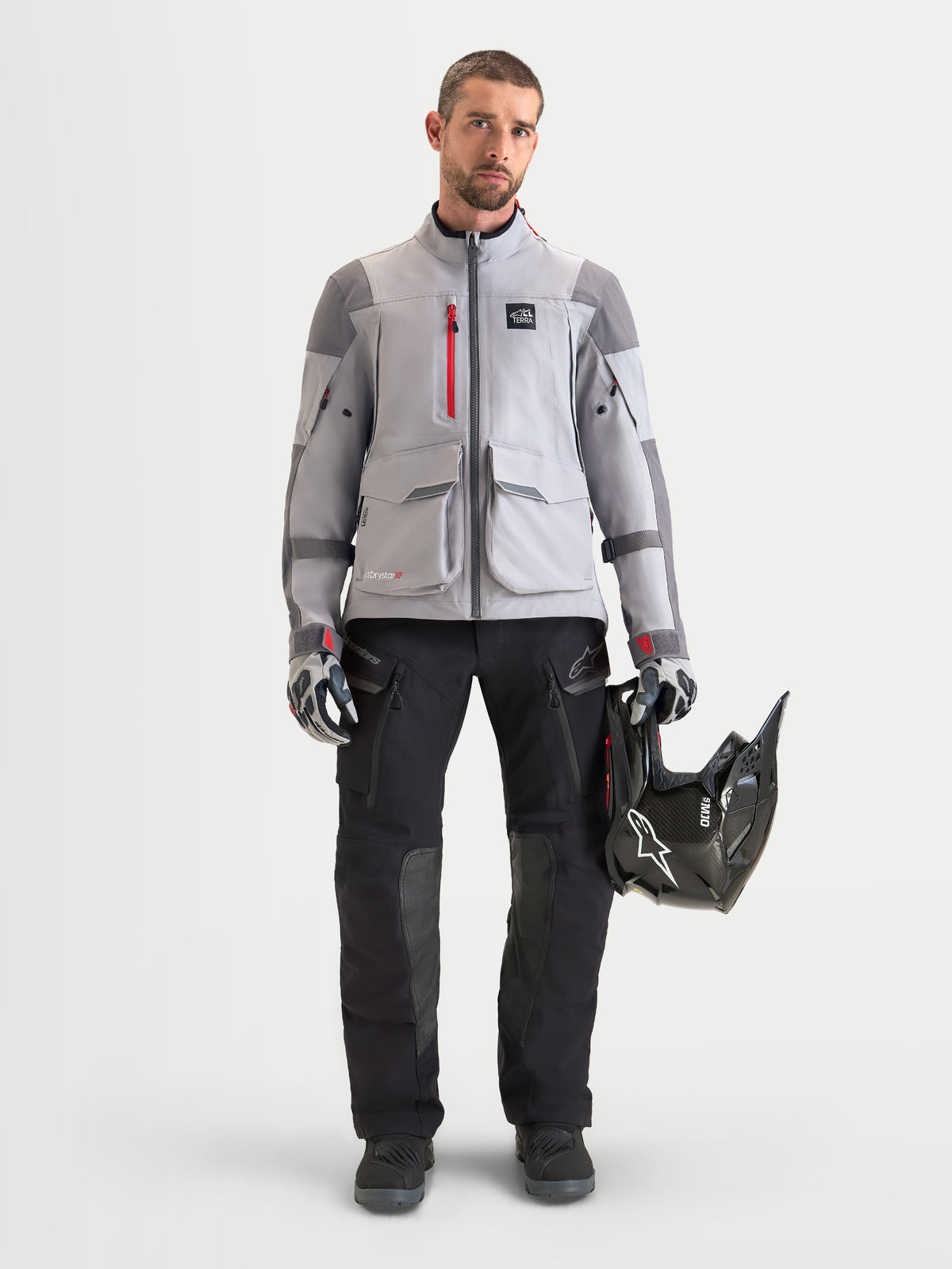 Alpinestars Maxdura Drystar XF, męskie spodnie motocyklowe adventure w kolorze czarnym i ciemnoszarym, prezentowane na modelu w komplecie z pasującą kurtką, rękawicami i kaskiem