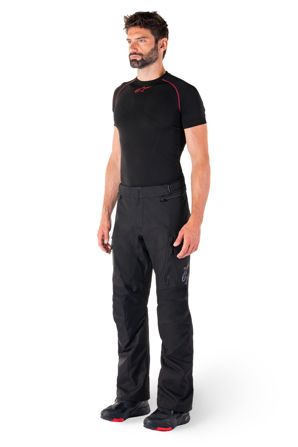 Alpinestars St-1 Waterproof Pants, Black, Adventure Touring Motorcycle Pants worn by a model with a black base layer and riding boots, featuring zippered pockets and reflective accents, durable textile construction for all-weather performance
