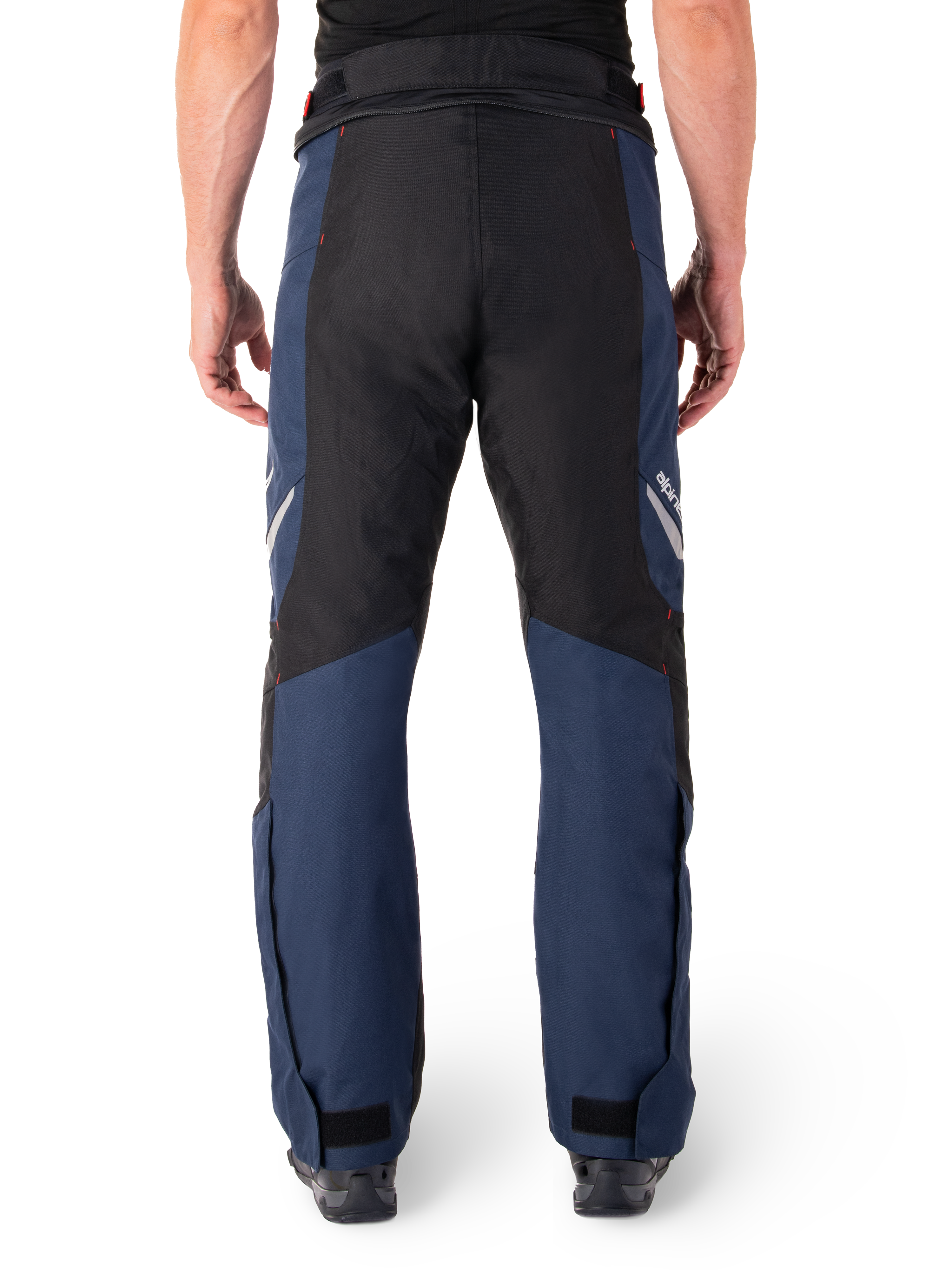 Alpinestars St-1 Waterproof Pants, motocyklowe spodnie turystyczne, ciemnoniebieskie i czarne z jaskrawoczerwonymi akcentami, widok z tyłu, opływowy krój turystyczny, wytrzymała konstrukcja tekstylna, odblaskowe logo, regulowane zapięcia na kostkach.