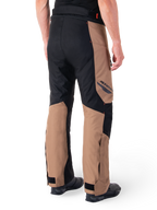 Alpinestars St-1 Waterproof Pants, Motorcycle Touring Pants, Dark Khaki Sand and Black with Red Fluo accents, rear three-quarter view, featuring Alpinestars branding on the thigh and adjustable ankle straps, worn with black boots.