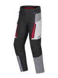 Alpinestars Honda ST-1 Waterproof Pants, turystyczne spodnie motocyklowe, kolory Ice Gray, Dark Gray i czarny z czerwonymi akcentami, techniczna konstrukcja tekstylna z wodoodporną podszewką, kieszenie cargo na zamek i ergonomiczne, profilowane nogawki