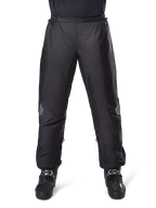 Alpinestars Bogota Pro Drystar 3 Seasons Pants, wodoodporne spodnie motocyklowe, czarne, lekka tkanina techniczna z odblaskowymi naszywkami na kolanach, noszone jako spodnie wierzchnie z czarnymi butami motocyklowymi, zaprojektowane dla ochrony przed warunkami pogodowymi w turystyce adventure