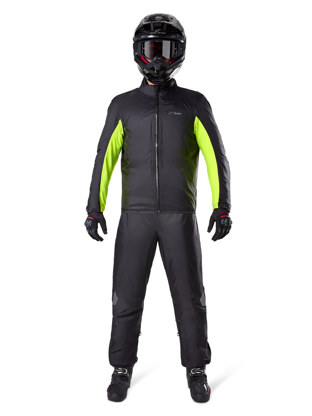 Spodnie Alpinestars Bogota Pro Drystar 3 Seasons, czarne, noszone przez motocyklistę w pełnym stroju adventure, zawierającym czarno-neonowożółtą wodoodporną kurtkę, czarny kask i buty motocyklowe, zaprojektowane z myślą o wydajności turystycznej w każdych warunkach pogodowych.