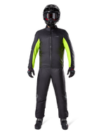 Spodnie Alpinestars Bogota Pro Drystar 3 Seasons, czarne, noszone przez motocyklistę w pełnym stroju adventure, zawierającym czarno-neonowożółtą wodoodporną kurtkę, czarny kask i buty motocyklowe, zaprojektowane z myślą o wydajności turystycznej w każdych warunkach pogodowych.